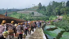 Warga membawa tenongan menuju makam sesepuh mereka saat mengikuti Sadranan Rejeban Plabengan di Lereng Gunung Sumbing, Temanggung, Jawa Tengah, Jumat (22/3). Dalam tradisi ini warga menggelar doa dan makan bersama di makam sesepuh. (Liputan6.com/Gholib)