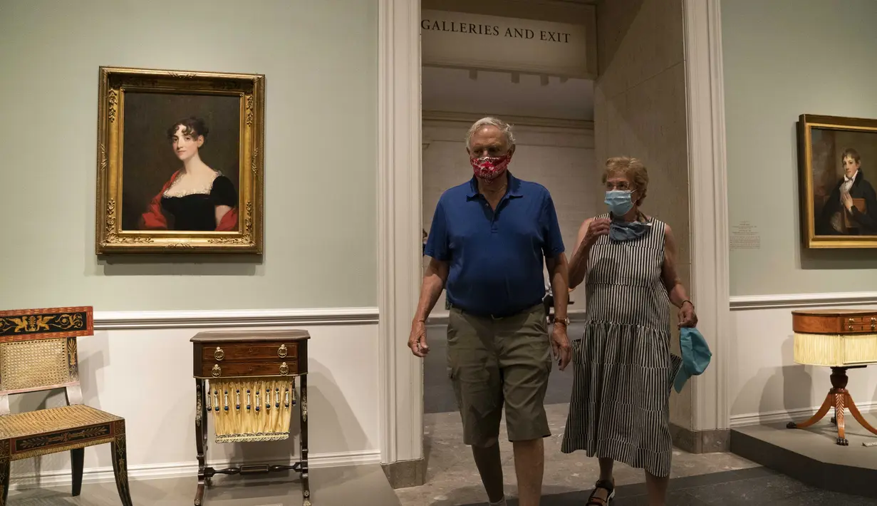 Pengunjung yang mengenakan masker melihat-lihat karya seni yang dipamerkan di Gedung Barat Galeri Seni Nasional di Washington DC, AS (20/7/2020). Sebagian galeri tersebut dibuka kembali untuk umum pada Senin (20/7) setelah ditutup selama berbulan-bulan akibat pandemi COVID-19. (Xinhua/Liu Jie)
