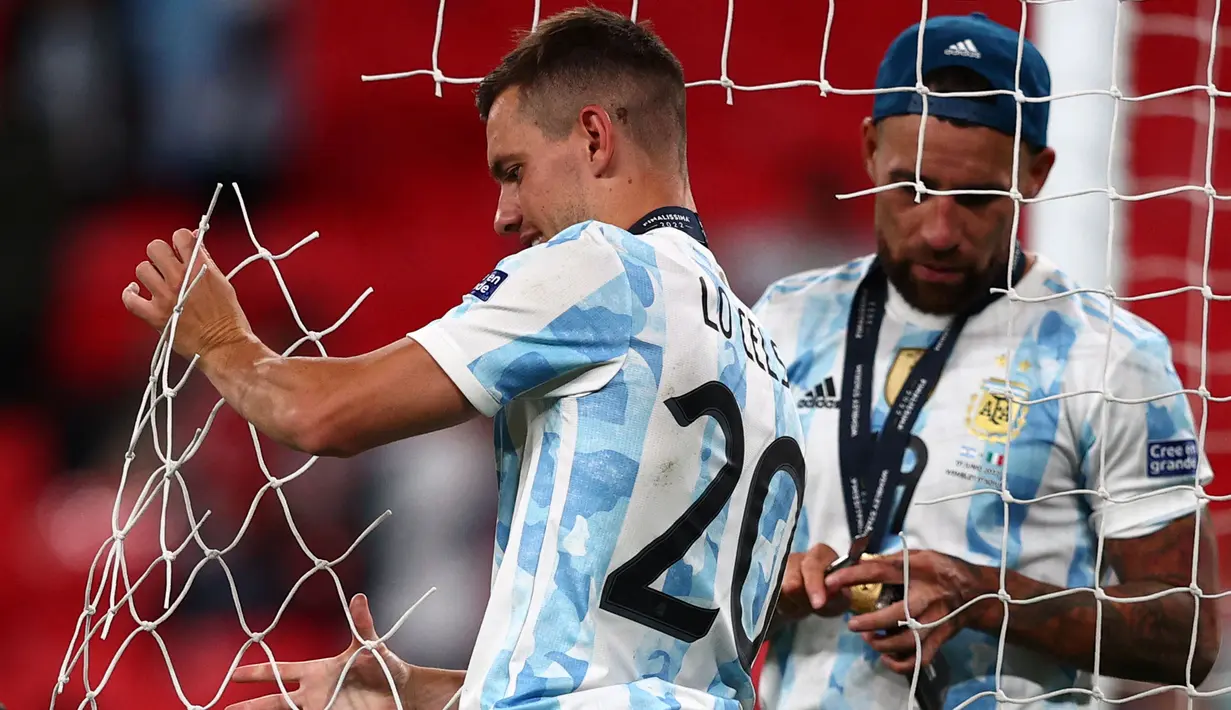 Pemain Argentina, Giovani Lo Celso (kiri) dan Nicolas Otamedi memotong jaring gawang setelah memenangkan laga Finalissima melawan Italia dengan skor 3-0 di Stadion Wembley, Kamis (02/06/2022) dini hari WIB. Gol La Albiceleste masing-masing dicetak oleh Lautaro Martinez (28'), Angel Di Maria (45+1'), dan Paulo Dybala (90+4'). (AFP/Adrian Dennis)