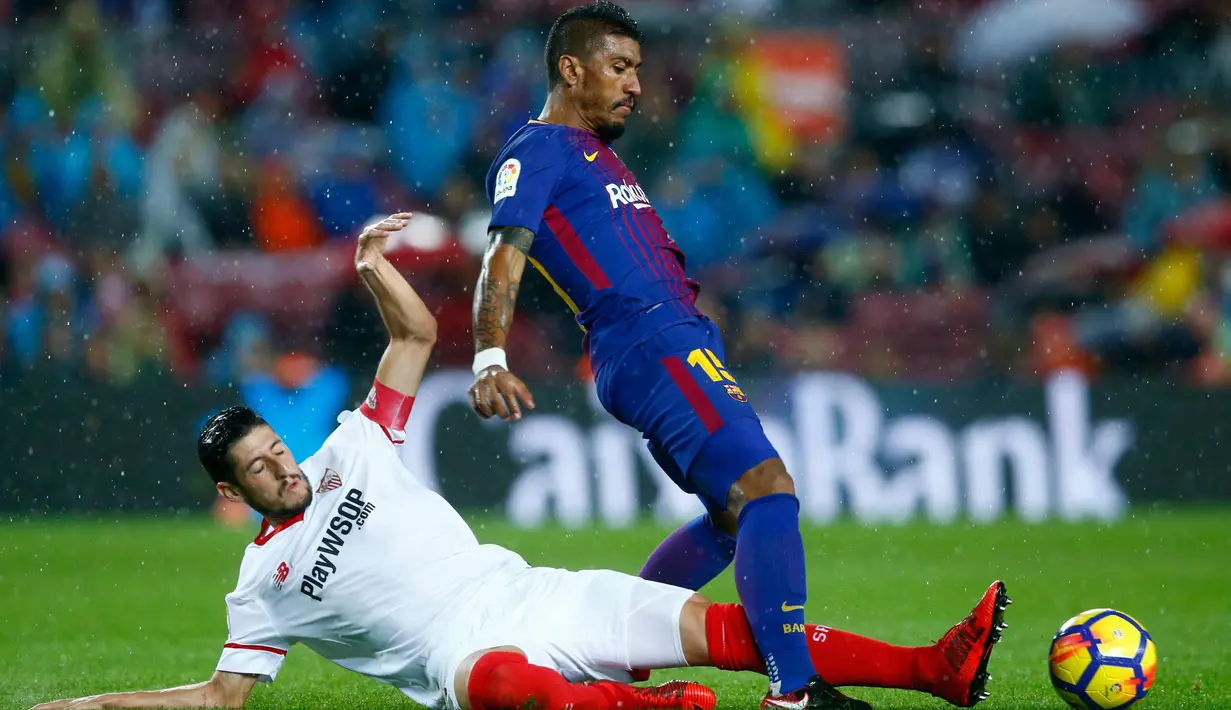 Gelandang Barcelona, Paulinho berusaha membawa bola dari kawalan pemain Sevilla, Sergio Escudero saat bertanding pada lanjutan La Liga Spanyol di Camp Nou, Barcelona, Spanyol, (4/11). Barcelona menang 2-1 atas Sevilla. (AP Photo/Manu Fernandez)