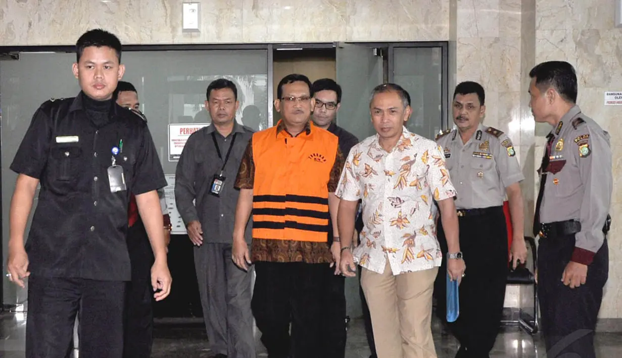 Didik Purnomo tampak tenang saat digiring dari Gedung KPK menuju mobil tahanan, Jakarta, Senin (11/11/2014). (Liputan6.com/Miftahul Hayat)