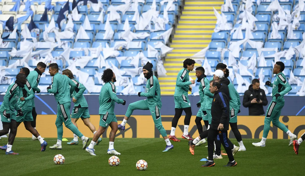 <p>Para pemain Madrid melakukan pemanasan saat sesi latihan tim di Stadion Etihad di Manchester, barat laut Inggris, pada 25 April 2022. Real Madrid akan bertanding melawan Manchester City pada leg pertama semifinal Liga Champions. (AFP/Oli Scarff)</p>