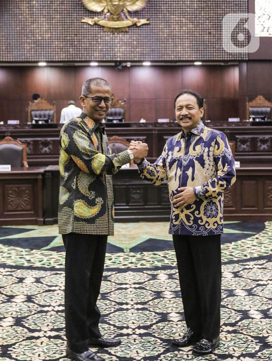 Ketua Mahkamah Konstitusi (MK) terpilih Suhartoyo (kanan) berjabat tangan dengan Wakil Ketua MK Sadil Isra (kiri) usai memberikan keterangan pers di Gedung Mahkamah Konstitusi, Jakarta, Kamis (9/11/2023). (Liputan6.com/Angga Yuniar)