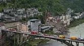 Kendaraan penyelamat bersiaga di jembatan saat tim penyelamat melakukan operasi pencarian dan penyelamatan di lokasi tanah longsor di Kabupaten Pengshui, Chongqing, Tiongkok barat daya, Sabtu, 18 Juli 2026. (AP Photo/Andy Wong)
