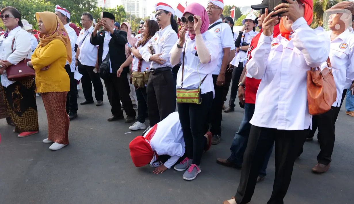 Reaksi relawan Joko Widodo-Ma'ruf Amin nonton bareng pelantikan Presiden dan Wakil Presiden di Taman Aspirasi, Jakarta, Minggu (20/10/2019). Jokowi dan Ma'ruf Amin resmi dilantik sebagai Presiden dan Wakil Presiden RI periode 2019-2024. (Liputan6.com/Herman Zakharia)