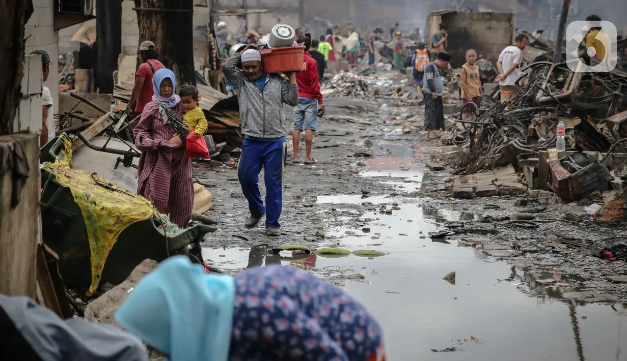 Warga membawa barang miliknya yang berhasil diselamatkan saat  kebakaran di Jalan Tanah Abang 5 RT 003,004/RW 003, Petojo Selatan, Gambir, Jakarta Pusat, Senin (27/2/2023). Adapun sebanyak 87 rumah tinggal, 250 bangunan semi permanen, dan 86 Kepala Keluarga (KK), dengan total 342 jiwa terdampak akibat kebakaran di Tanah Abang ini. (Liputan6.com/Faizal Fanani)