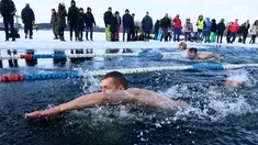 Peserta saat mengikuti kompetisi renang musim dingin tahunan dengan air es beku di Trakai, Lituania (24/2). Para peserta tetap antusias mengikuti lomba walaupun dengan suhu di luar hingga minus 12 derajat Celcius. (AFP Photo/Petras Malukas)