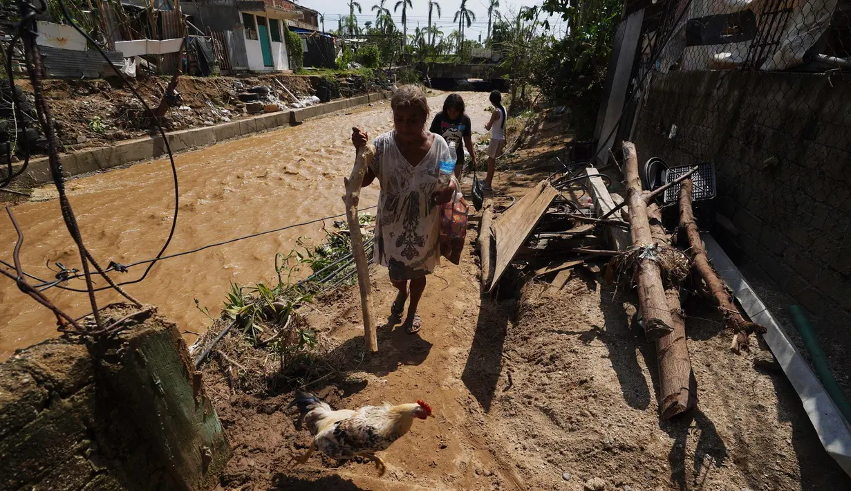 Margarita Ibanez berjalan di samping Sungai Postal setelah Badai Otis menerjang Acapulco, Meksiko, Kamis, 26 Oktober 2023. (AP Photo/Marco Ugarte)