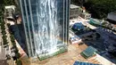 Pelangi tercipta dari air terjun yang mengalir di sisi gedung Liebian International Plaza di Kota Guiyang, China, 20 Juli 2018. Air terjun ini dikelola oleh Guizhou Ludiya Property Management Co., dan dirancang untuk menjadi objek wisata. (AFP/China OUT)
