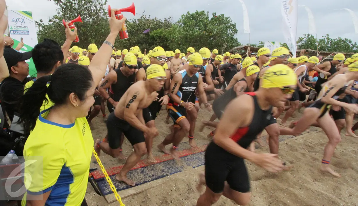 Country GM Herbalife Indonesia Andam Dewi membunyikan terompet tanda dimulainya Herbalife Bali International Triathlon 2016 di Sanur, Bali, Minggu (14/8). Sebanyak 1754 peserta dari 26 negara, ikut dalam lomba tersebut. (Liputan6.com/Made Anto)
