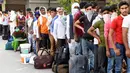 Pekerja migran yang terdampar dan keluarga mereka berkumpul menunggu pemeriksaan medis sebelum pergi dengan kereta api untuk kembali ke kota asal mereka ke Jaunpur, negara bagian Uttar Pradesh, setelah pemerintah melonggarkan lockdown di Amritsar, India, Selasa (19/5/2020). (NARINDER NANU/AFP)