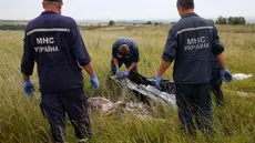 Tim penyidik Ukraina tampak menyiapkan kantong mayat untuk membawa jenazah dan sisa barang-barang dari puing Malaysia Airlines MH-17 (REUTERS/Maxim Zmeyev)