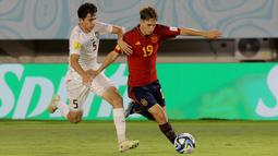 Pemain Timnas Spanyol U-17, Daniel Yanez (kanan), mengontrol bola dibayangi pemain Timnas Uzbekistan U-17, Azizbek Tulkunbekov dalam laga pamungkas Grup B Piala Dunia U-17 2023 yang berlangsung di Stadion Manahan, Solo, Kamis (16/11/2023) sore WIB. (Bola.com/Arief Bagus Prasetiyo)