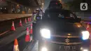 Petugas kepolisian memeriksa dokumen pengendara di Pintu Tol keluar Cikarang Barat, kabupaten Bekasi, Jawa Barat, Kamis (6/5/2021) dini hari. Pemeriksaan sebagai upaya mengantisipasi risiko peningkatan kasus penularan COVID-19 jelang Hari Raya Idul Fitri 1442 H. (Liputan6.com/Herman Zakharia)