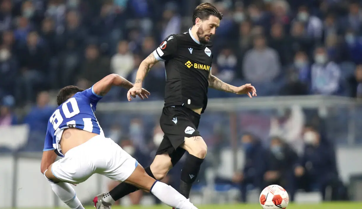 Pemain Porto Evanilson (kiri) mencoba untuk menjegal pemain Lazio Luis Alberto pada pertandingan Liga Europa di Stadion Dragao, Porto, Portugal, 17 Februari 2022. Porto menang 2-1. (AP Photo/Luis Vieira)