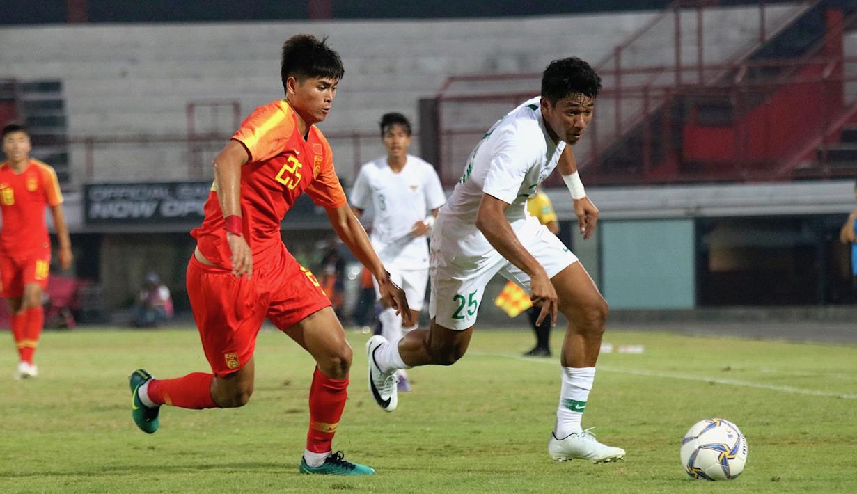 Striker China U-19, Tayier Xiaokaitijiang, berebut bola dengan striker Timnas Indonesia U-19, Serdy Ephy Fano Boky, pada laga ujicoba di Stadion I Wayab Dipta, Bali, Minggu (20/10). Indonesia kalah 1-3 dari China. (Bola.com/Aditya Wany)