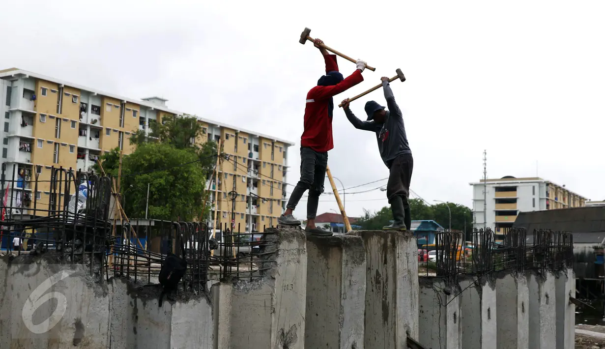 Pekerja merapikan dinding turap yang dipasang di Kali Gendong, Penjaringan, Jakarta, Senin (10/10). Pemasangan itu untuk menguatkan dinding kali agar tidak longsor sekaligus sebagai salah satu antisipasi banjir Ibu Kota. (Liputan6.com/Gempur M Surya)