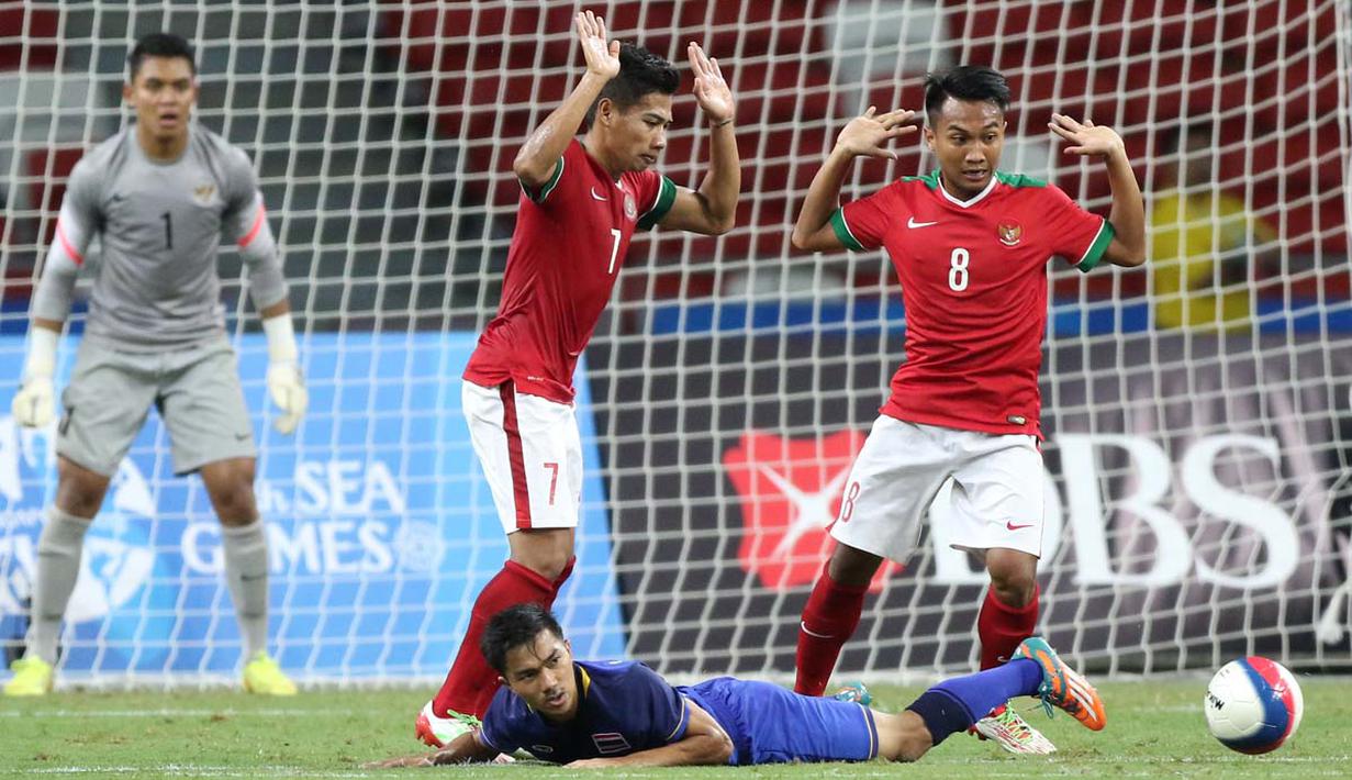 Pemain Indonesia U-23, Ahmad Nufiandani dan M. Hargianto, berebut bola dengan pemain Thailand U-23.  (Bola.com/Arief Bagus)