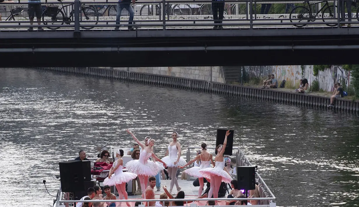 Anggota Staatsballett Berlin menari di atas kapal pesiar selama tur melalui pusat kota di Berlin, Jerman, Kamis (10/6/2021). Pertunjukan itu diikuti oleh banyak orang di sepanjang rute. (Paul Zinken/dpa via AP)