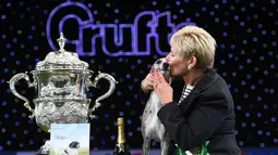 Yvette Short mencium anjing  the Whippet miliknya setelah dinobatkan sebagai pemenang Best in Show pada hari terakhir Crufts dog show 2018 di Birmingham, Inggris (11/3). Crufts adalah salah satu acara anjing terbesar di dunia. (AFP Photo/Oli Scarff)