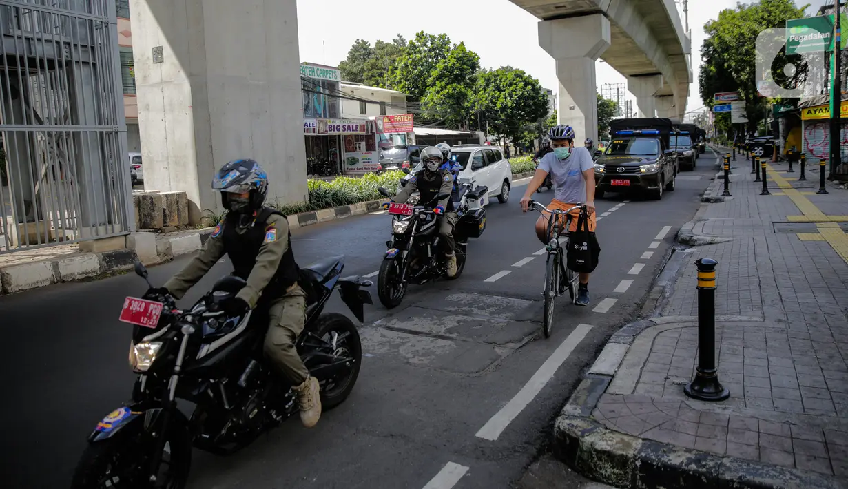 Petugas gabungan dari Satpol PP, Dishub, polisi hingga TNI melakukan patroli di kawasan Jalan Fatmawati, Jakarta, Kamis (15/4/2020). Patroli gabungan tersebut untuk mengimbau masyarakat agar tetap dirumah dan selalu menggunakan masker saat beraktivitas di luar rumah. (Liputan6.com/Faizal Fanani)