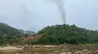 Kebakaran pangkalan militer Myanmar sepanjang tepi Sungai Salween terlihat dari Kota Mae Sam Laep, Provinsi Mae Hong Son, Thailand, Selasa (27/4/2021). Pemberontak Persatuan Nasional Karen menyerang pangkalan militer Myanmar karena kekacauan setelah kudeta militer. (Handout/KAWTHOOLEI TODAY/AFP)