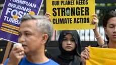 Aktivis lingkungan menggelar aksi unjuk rasa mendesak pemerintah Indonesia untuk menunjukkan komitmen terhadap transisi dari bahan bakar fosil di depan kantor Kementerian Energi dan Sumber Daya Mineral (ESDM), Jakarta, Rabu 22 April 2026. Sejumlah aktivis lingkungan menggelar aksi unjuk rasa mendesak pemerintah Indonesia untuk mempercepat transisi dari bahan bakar fosil menuju energi yang lebih ramah lingkungan. (BAY ISMOYO/AFP)