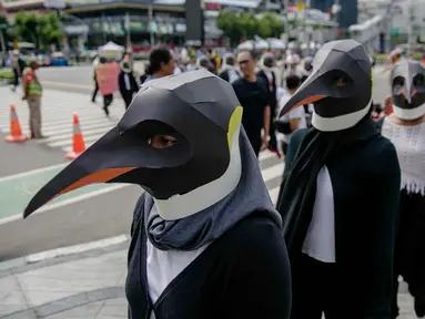 Sejumlah aktivis Greenpeace mengenakan topeng penguin saat menggelar aksi dalam car free day di kawasan Thamrin, Jakarta, Minggu (9/2/2020). Mereka mengajak pemerintah untuk berpartisipasi dalam mewujudkan Perjanjian Laut Internasional (Global Ocean Treaty). (Liputan6.com/Faizal Fanani)