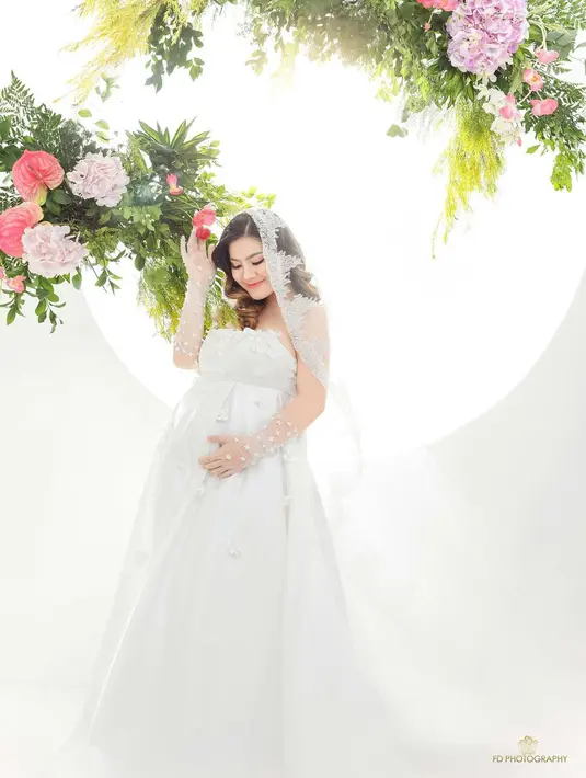 Felicya Angelista tampil serba putih di maternity shoot anak keduanya. Tampil super cantik dengan strapless dress putih penuh bordir yang cantik, penampilan Felicya disempurnakan dengan penutup kepala transparan bak pengantin. [Foto: Instagram/fdphotography90]