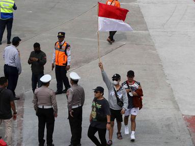 Seorang warga mengibarkan bendera merah putih saat perayaan pawai Timnas U-22 dan Juara SEA Games 2023 di kawasan Bundaran HI, Jakarta, Jumat (19/5/2023). (Liputan6.com/Herman Zakharia)