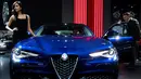 Model berpose di samping Alfa Romeo Giulia saat pameran North American International Auto Show 2017 di Detroit, Michigan, AS (9/1). Pameran ini diadakan dari tanggal 8 sampai 22 Januari 2017. (AFP Photo/Jim Watson)