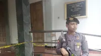 Petugas memasang garis polisi di pintu Gereja St Lidwina Bedog, Sleman, Yogyakarta, Minggu (11/2). (Liputan6.com/Yanuar H)