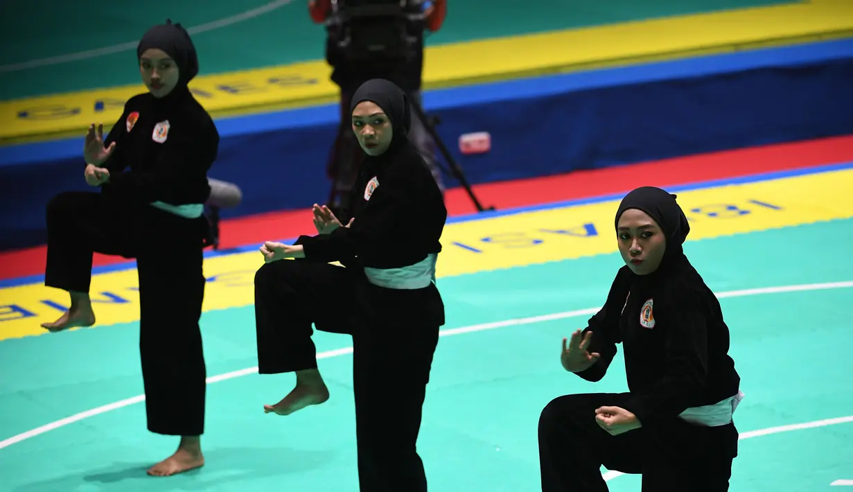 Tim pencak silat seni beregu putri Indonesia, Pramudita Yuristya (kiri), Lutfi Nurhasanah (tengah) dan Gina Tri Lestari (kanan) tampil dalam babak final Asian Games 2018 di TMII, Jakarta, Rabu (29/8). (ANTARA FOTO/INASGOC/Melvinas Priananda/nak/18)