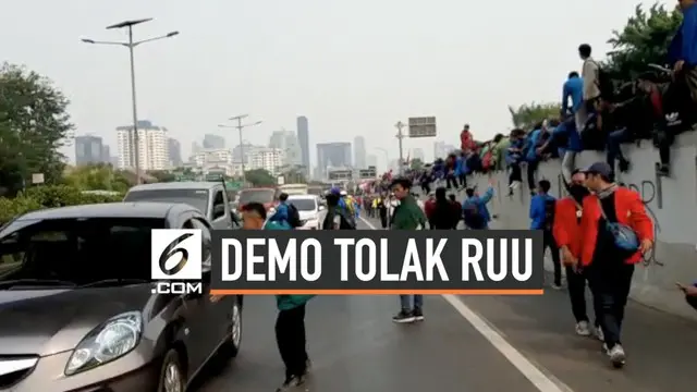 Mahasiswa yang menggelar demonstrasi di depan Gedung DPR RI menutup jalan tol dalam kota yang membentang di depan Gedung DPR.