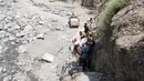 Warga membawa persediaan makanan setelah banjir bandang menghantam wilayah Ursoon, daerah terpencil Chitral di Pakistan utara, Minggu (3/7). Banjir merusak sejumlah rumah dan sebuah masjid dengan jumlah korban tewas 43 orang (GUL HAMAAD Farooqi/AFP)