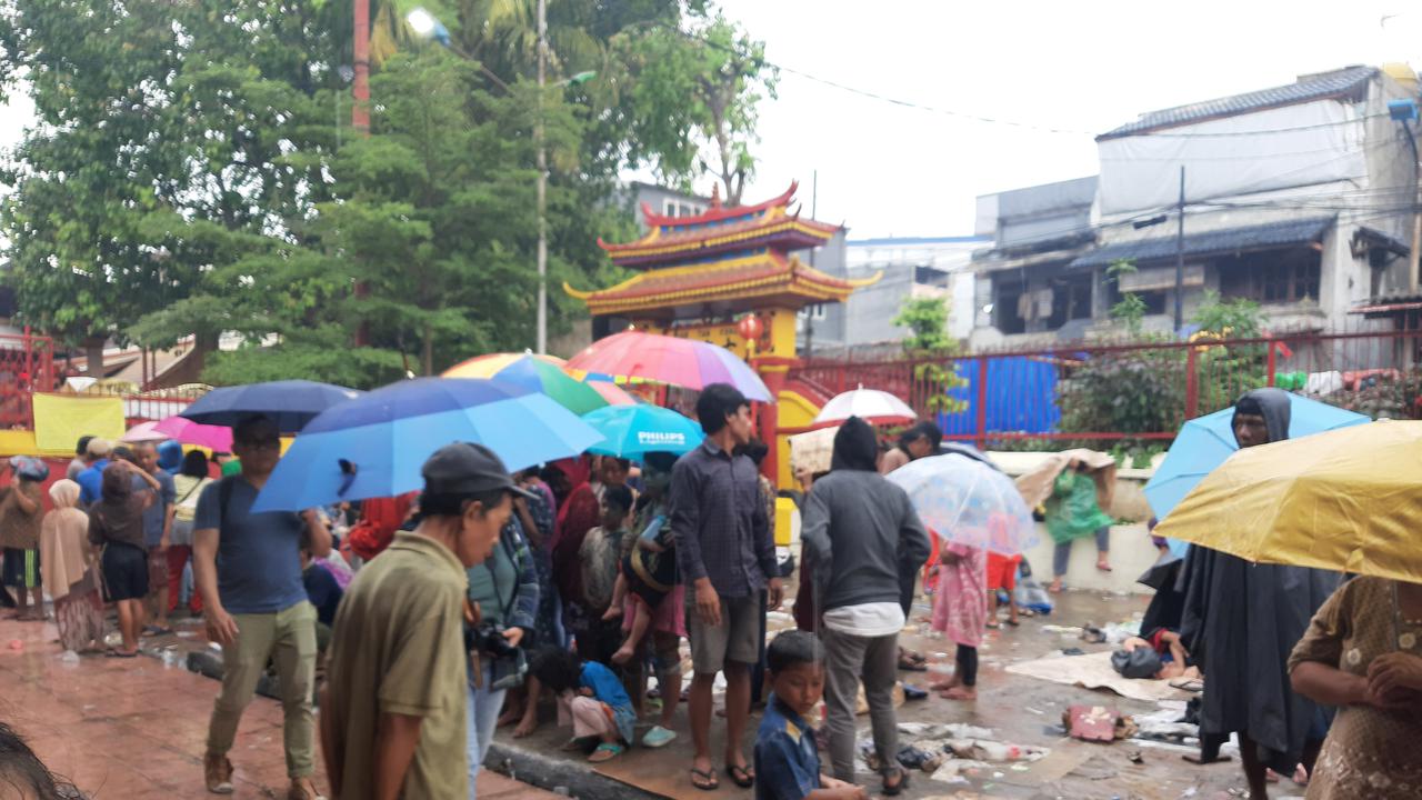 Warga yang sejak pagi tadi datang ke Wihara Dharma Bakti untuk memburu angpao Imlek tetap bertahan meski hujan,
