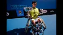 Shingo Kunieda berpose dengan trofinya setelah mengalahkan Stephane Houdet dari Perancis di tunggal pria kursi roda di turnamen tenis Australia Terbuka 2015, Melbourne,Australia,  (31/1/2015). (REUTERS / Issei Kato)