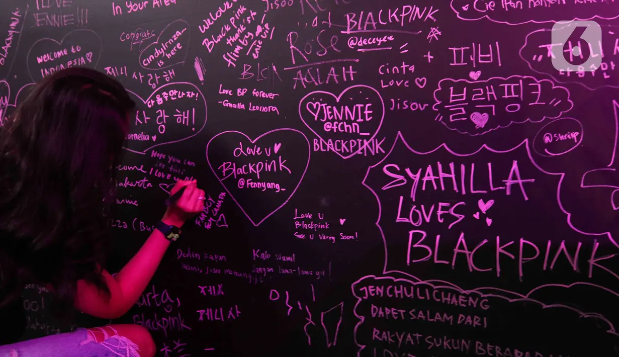 Pengunjung menuliskan pesan pada acara BLACKPINK In Your Area Pop-up Store and Exhibition di Senayan Park, Jakarta, Selasa (7/3/2023). Pameran pada 6 Maret - 6 April 2023 ini menampilkan sejumlah pakaian dan barang asli yang pernah digunakan oleh para member Blackpink untuk memeriahkan konser Born Pink di Jakarta akhir pekan mendatang. (Liputan6.com/Herman Zakharia)