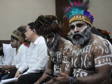 Tersangka kasus pengibaran bendera Bintang Kejora, Dano Tabuni (kanan) dan Ambrosius Mulait saat menunggu dimulainya sidang di Pengadilan Negeri Jakarta Pusat, Jakarta, Kamis (19/12/2019). Sidang rencananya mendengar dakwaan Jaksa Penuntut Umum. (Liputan6.com/Helmi Fithriansyah)