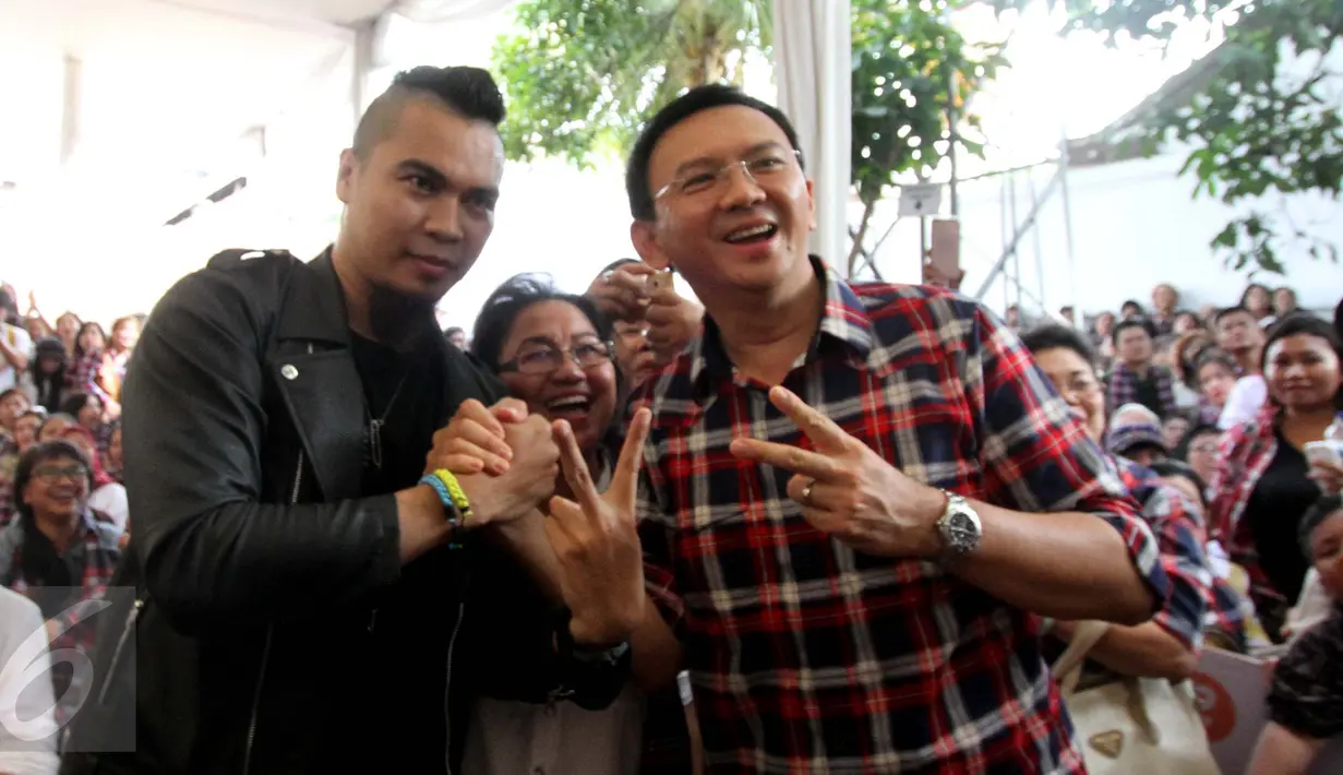 Cagub DKI Jakarta, Basuki Tjahaja Purnama (Ahok) berfoto bersama seorang pria yang mirip musisi Ahmad Dhani di Rumah Lembang, Jakarta, Rabu (25/1). Pria bernama Yoram itu menjadi buruan foto bersama pengunjung Rumah Lembang. (Liputan6.com/Gempur M Surya)