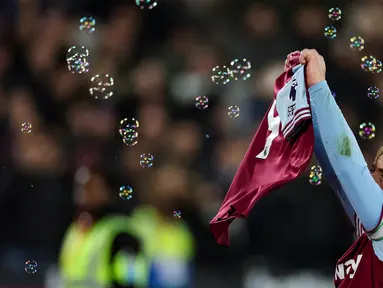 Pemain West Ham United, Jarrod Bowen melakukan selebrasi dengan menunjukkan jersey milik Michail Antonio pada laga lanjutan Liga Inggris 2024/2025 melawan Wolves di London Stadium, London, Inggris, Selasa (10/12/2024) WIB. (AFP/Adrian Dennis)