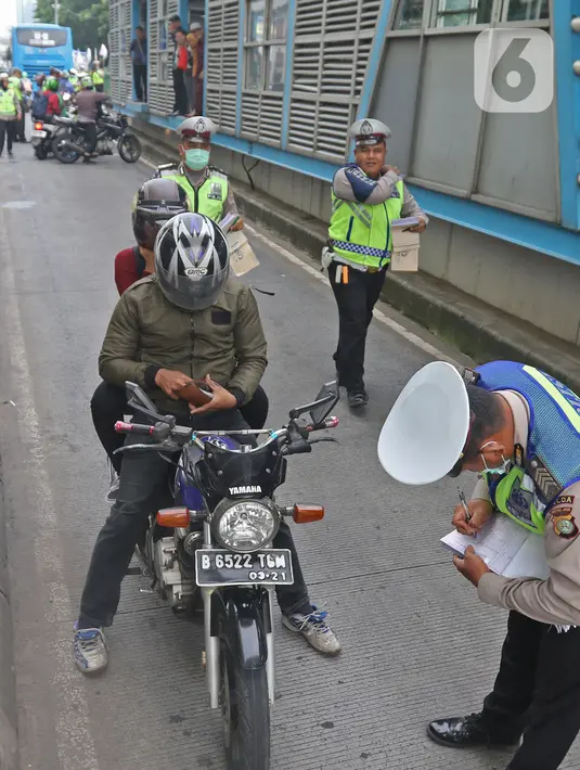 Polisi menilang pengendara sepeda motor yang menerobos jalur Transjakarta di Jalan Sultan Agung, Manggarai, Jakarta, Rabu (12/2/2020). Pengendara kerap melintasi jalur Transjakarta untuk menghindari kemacetan lalu lintas. (Liputan6.com/Herman Zakharia)