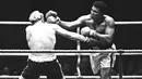 Muhammad Ali saat menghantam Richard Dunn dengan pukulan keras dalam turnamen WBC & WBA kelas berat di Munich, Jerman, (24/5/1976). Ali wafat pada usia 74 tahun dan dimakamkan di kota kelahirannya di Louisville, Kentucky. (REUTERS/Action Images/MSI)