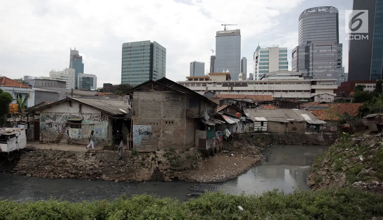 Anak-anak sekolah melintas di Kampung Kuningan Timur, Jakarta, Kamis (11/1). Permukiman warga miskin di kampung tersebut terlihat kontras dengan pembangunan hunian bertingkat mewah dan pusat-pusat perbelanjaan di sekitarnya. (Liputan6.com/Arya Manggala)