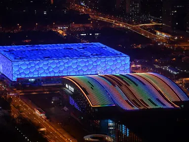 National Aquatics Center yang dikenal sebagai Ice Cube (kiri) venue untuk curling dan National Indoor Stadium (kanan) venue untuk hoki es pada Olimpiade Musim Dingin 2022 terlihat di Beijing, 3 Januari 2022. Olimpiade Musim Dingin 2022 akan dibuka pada 4 Februari mendatang. (GREG BAKER/AFP)
