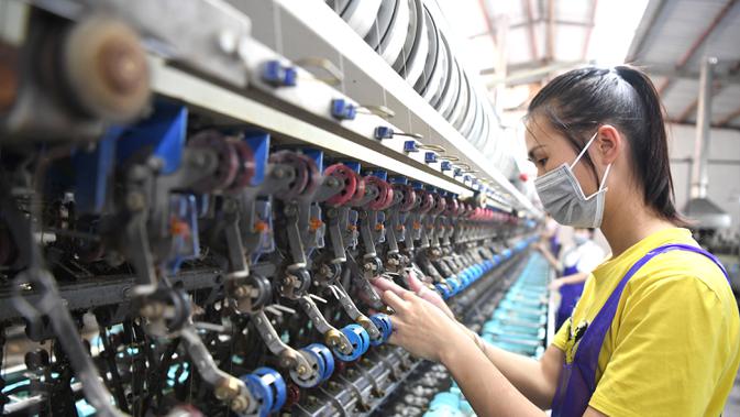 Seorang pegawai bekerja di pabrik penggulungan sutra di Wilayah Lingyun, Daerah Otonom Etnis Zhuang Guangxi, China selatan, 17 April 2020. Guangxi melakukan percepatan pembangunan infrastruktur transportasi di daerah miskin dan pelaksanaan proyek air minum. (Xinhua/Zhou Hua)