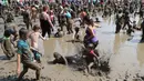 Ratusan anak bermain dalam kubangan berisi lumpur saat perayaan Mud Day atau Hari Lumpur Tahunan di Westland, Michigan, AS, Selasa (10/7). Dalam Mud Day kali ini para pesertanya yang ikut adalah anak-anak.  (AP/Carlos Osorio)