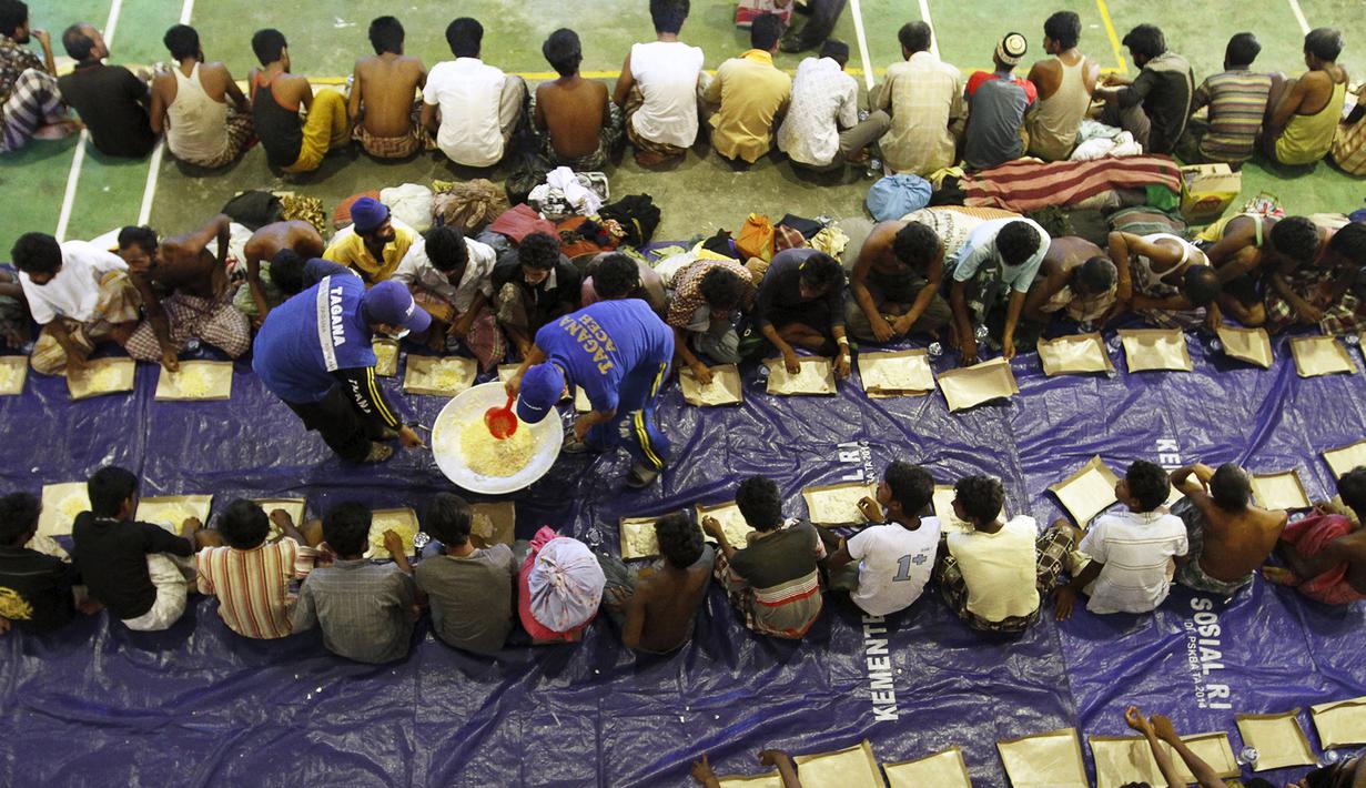 Petugas Tagana memberikan makanan kepada pengungsi etnis Rohingya di Lhoksukon, Aceh, Senin (11/5/2015). Sekitar 500 migran terdampar di pantai Aceh setelah terapung-apung di laut selama sebulan karena kehabisan bahan bakar. (REUTERS/Roni Bintang)