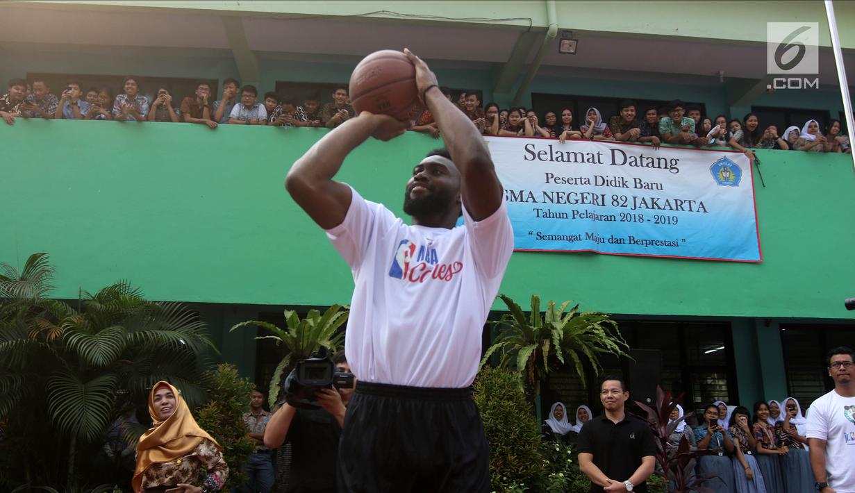 Pemain NBA dari Boston Celtics, Jaylen Brown memberi melempat bola basket saat coaching clinics untuk siswa-siswi di SMAN 82 Jakarta, Kamis (26/7). Kegiatan tersebut untuk memperkenalkan olahraga basket bagi anak-anak. (Liputan6.com/Arya Manggala)