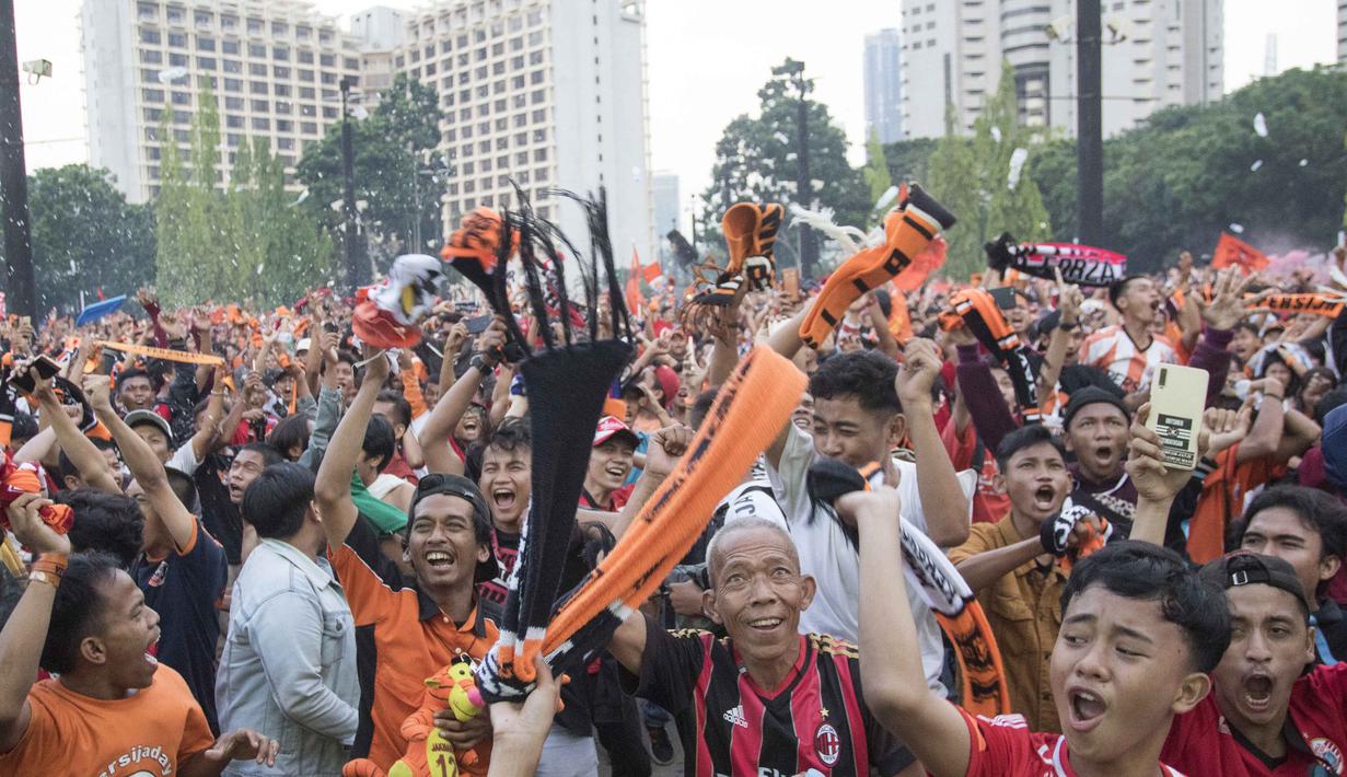 Suporter Persija Jakarta, The Jakmania, merayakan gelar juara Liga 1 saat nonton bareng di Plaza Timur Senayan, Jakarta, Minggu (9/12). Persija juara Liga 1 setelah menang 2-1 atas Mitra Kukar. (Bola.com/Peksi Cahyo)